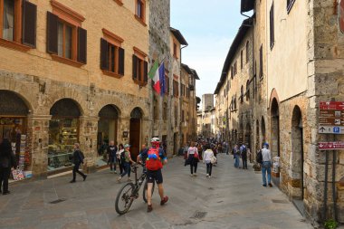 San Gimignano, İtalya - 30 Nisan 2023: Eski San Gimignano kasabasını ziyaret eden turistler. Kasaba ortaçağ mimarisi ile ünlüdür..