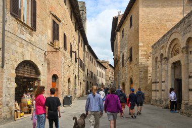 San Gimignano, İtalya - 30 Nisan 2023: Eski San Gimignano sokaklarını ziyaret eden turistler. Kasaba ortaçağ mimarisi ile ünlüdür..