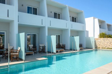 Kos, Yunanistan - 13 Mayıs 2023: Kos adasındaki Marmari köyünde 4 yıldızlı bir tatil köyü olan Sandy Beach otelinin havuz alanına sahip daireler. Yunanistan