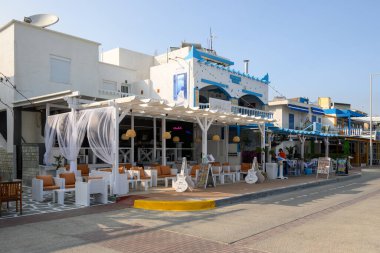 Kos, Yunanistan - 12 Mayıs 2023: Kardamena tatil beldesinde dükkanları ve restoranları olan kıyı yürüyüşü. Kos Adası, Yunanistan