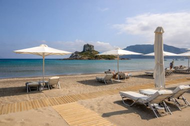 Kos, Yunanistan - 12 Mayıs 2024: Agios Stefanos plajı, Kos adasında uzun bir kumsal ve ince çakıl taşları. Yunanistan