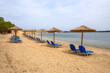 Sun loungers on sandy Limnionas beach. Kos island, Dodecanese, Greece clipart