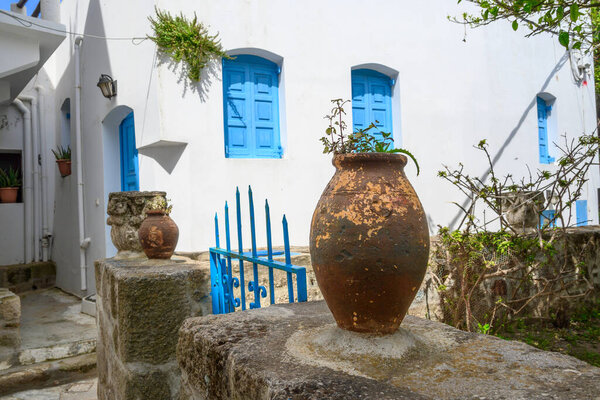 An old flowerpot against the background of a Greek house in Nikia village on Nisyros island. Greece