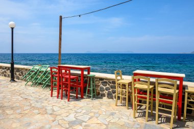 Nisyros adasındaki tipik bir Yunan sahil restoranında masa ve sandalyeler. Yunanistan