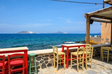 Nisyros adasındaki tipik bir Yunan sahil restoranında masa ve sandalyeler. Yunanistan
