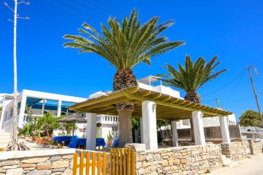 Ano Koufonisi, Yunanistan - 15 Mayıs 2024: Ano Koufonisi adasında palmiye ağaçları olan Yunan restoranı. Erkek Kiklad, Yunanistan