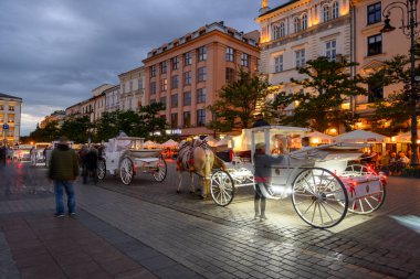 Krakow, Polonya - 16 Eylül 2022: Krakow Eski Kasabası 'ndaki ana pazar meydanında at arabası. Polonya