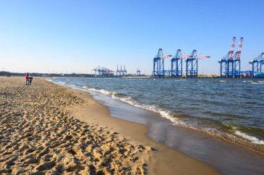 Gdansk, Polonya - 23 Mart 2025: Baltık Denizi kıyısındaki Stogi Sahili. Arka planda büyük vinçler var. Polonya