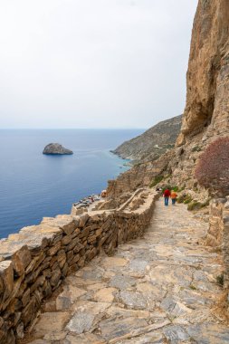 Amorgos, Yunanistan - 17 Mayıs 2024: Hozoviotissa Manastırı 'na giden basamaklardaki turistler. Amorgos adası. Cyclades, Yunanistan