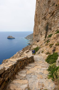 Amorgos, Yunanistan - 17 Mayıs 2024: Hozoviotissa Manastırı 'na giden basamaklardaki turistler. Amorgos adası. Cyclades, Yunanistan