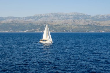 Adriyatik Denizi 'nde bir yat, arkasında da Hırvat kıyıları var.