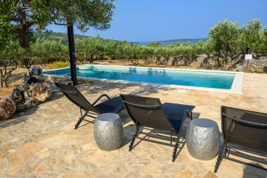 Brac, Hırvatistan - 10 Haziran 2025: Hırvatistan 'ın Brac adasında yazlık villalarla yüzme havuzu