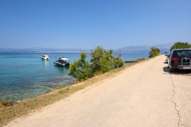 Brac, Hırvatistan - 14 Haziran 2025: Brac adasında Sutivan yakınlarında yer alan Likva Körfezi boyunca uzanan sahil yolu. Hırvatistan