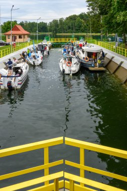 Ruciane-Nida, Polonya - 5 Ağustos 2025: Ruciane-Nida köyündeki Guzianka I 'de bekleyen tekne ve yatlar. Masurian Gölleri, Polonya