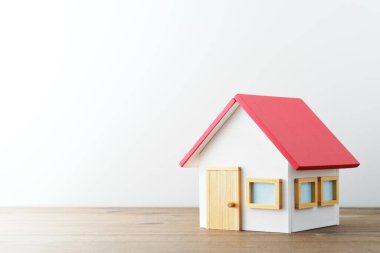 Miniature house on wood table. White background with copy space