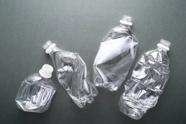 Four crush bottles on dark background. Waste of plastic bottles