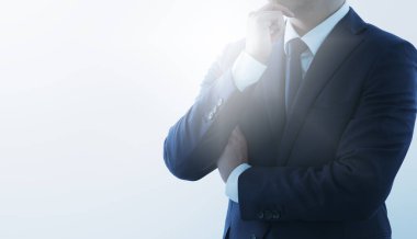 Düşünen bir iş adamı ve ilham kaynağı. Mavi takım elbiseli. Arkaplan ışığı ve kopyalama alanı.