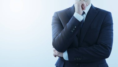 Düşünen bir iş adamı. Mavi takım elbiseli. Kopya alanı ile ön görünüm. Arkaplan ışığı ve işaret fişeği.