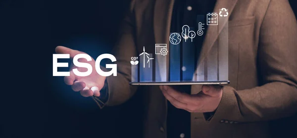 Tablet kullanan bir adam. ESG çevre sosyal yönetim yatırım konsepti. İş yatırım stratejisi kavramında bilgisayar ekranında ESG simgeleri ortaya çıkıyor