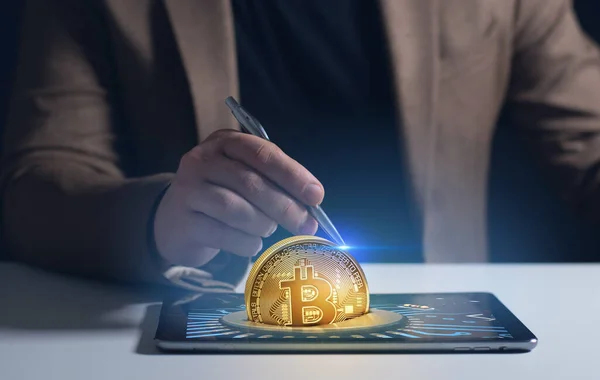 Altın bitcoin kripto para birimi ve tablet gösteren iş adamı engelleme teknolojisi konseptine sahip, dijital varlık sanal pazarına elektronik para yatırımı, gelecekteki küresel ticaret ticareti