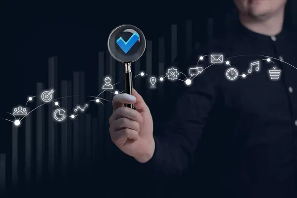 Businessman holding a magnifying glass, showing Audit Document concept,quality assessment management With a checklist, business document evaluation process, market data report analysis and consulting
