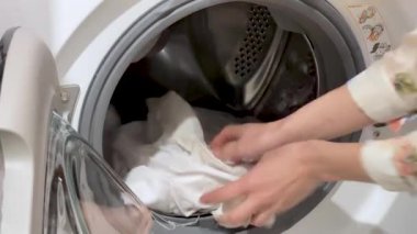 Çamaşır makinesi farklı giysileri ve çarşafları yıkar. Silindir dönüyor. Kimse..