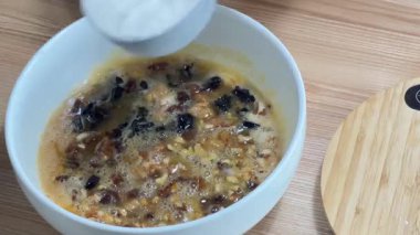 Pişirmek için malzemeleri karıştırıyorum. Yumurtaya, fındığa ve üzüme un ekliyorum..