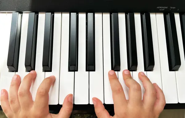 Elektronik piyanoda çocuk elleri