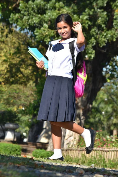 Female Student Wearing School Uniform Holding Books