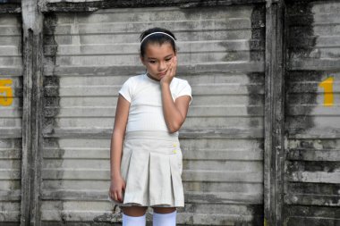 Mutsuz genç Filipinli Kız Duvarın yanında