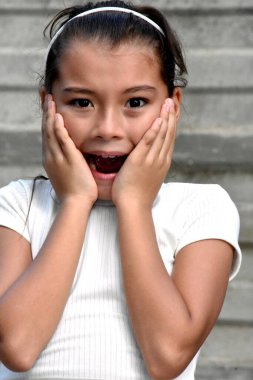 Duvarın yanında saç bandı takan ürkmüş şirin kızlar.