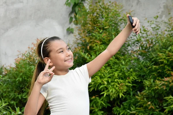 Una Chica Usando Una Banda Pelo Con Teléfono —  Fotos de Stock