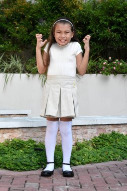 Stres altındaki sevimli Filipinli çocuk. Park yerinde duran etek giyiyor.