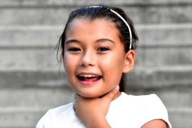 Duvarın yanında saç bandı takan hastalıklı, çeşitli tipli çocuk.