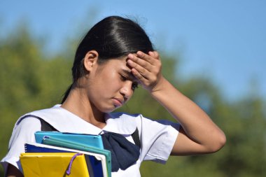 Baş ağrısı çeken, üniformalı liseli kız.