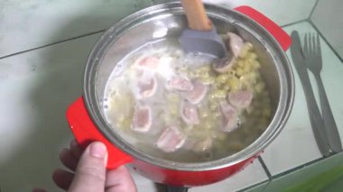 Kadın tavuklu erişte pişiriyor.