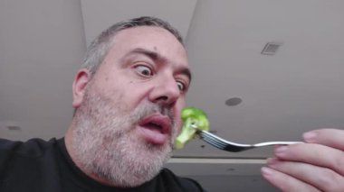 A Funny Older Man Eating Broccoli