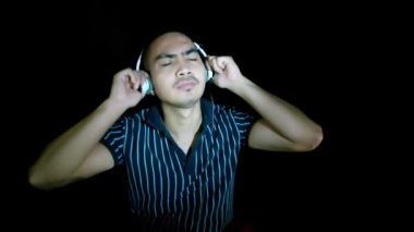 An Asian Man Listening To Music