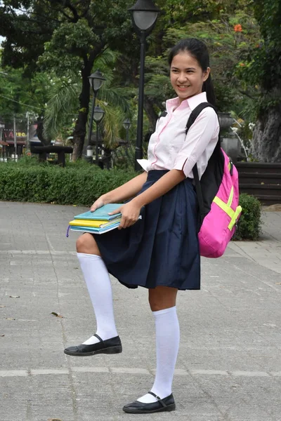 Happy Filipina Female Student Wearing School Uniform With Textbooks Standing