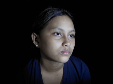 Yüzünde hüzünlü bir ifade olan genç Asyalı kadın.