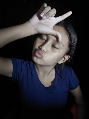 Siyah arka planda beyaz elbiseli genç bir kızın portresi.