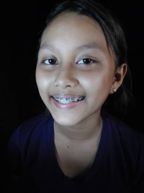 Mutlu Asyalı bir kız gülümsüyor.