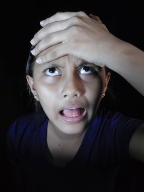 Korkmuş çocuk kameraya bakıyor.