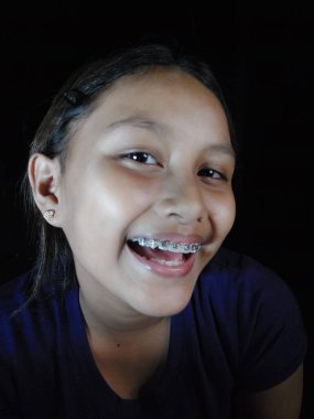 Beyaz bir geçmişi olan gülümseyen bir kızın portresi.