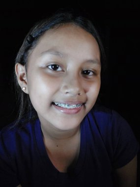 Beyaz gömlekli ve mavi eşarplı bir kız.