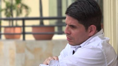 Beyaz gömlek giyen endişeli bir adam.