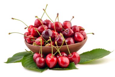 Beyaz arka planda olgun kirazlar kasede yakın plan.