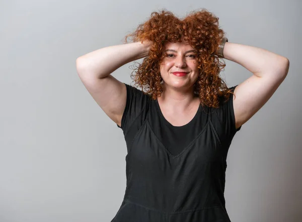 stock image Happy woman with red curly hair posing on grey background, with copy space 