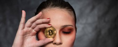 Elinde bitcoin tutan güzel bir kadın, farklı yüz ifadeleriyle, stüdyo çekimi.