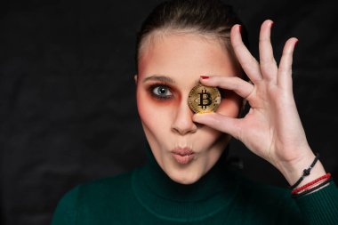 Elinde bitcoin tutan güzel bir kadın, farklı yüz ifadeleriyle, stüdyo çekimi.